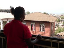 Marion Kargbo stands at a balcony in Freetown, Sierra Leone